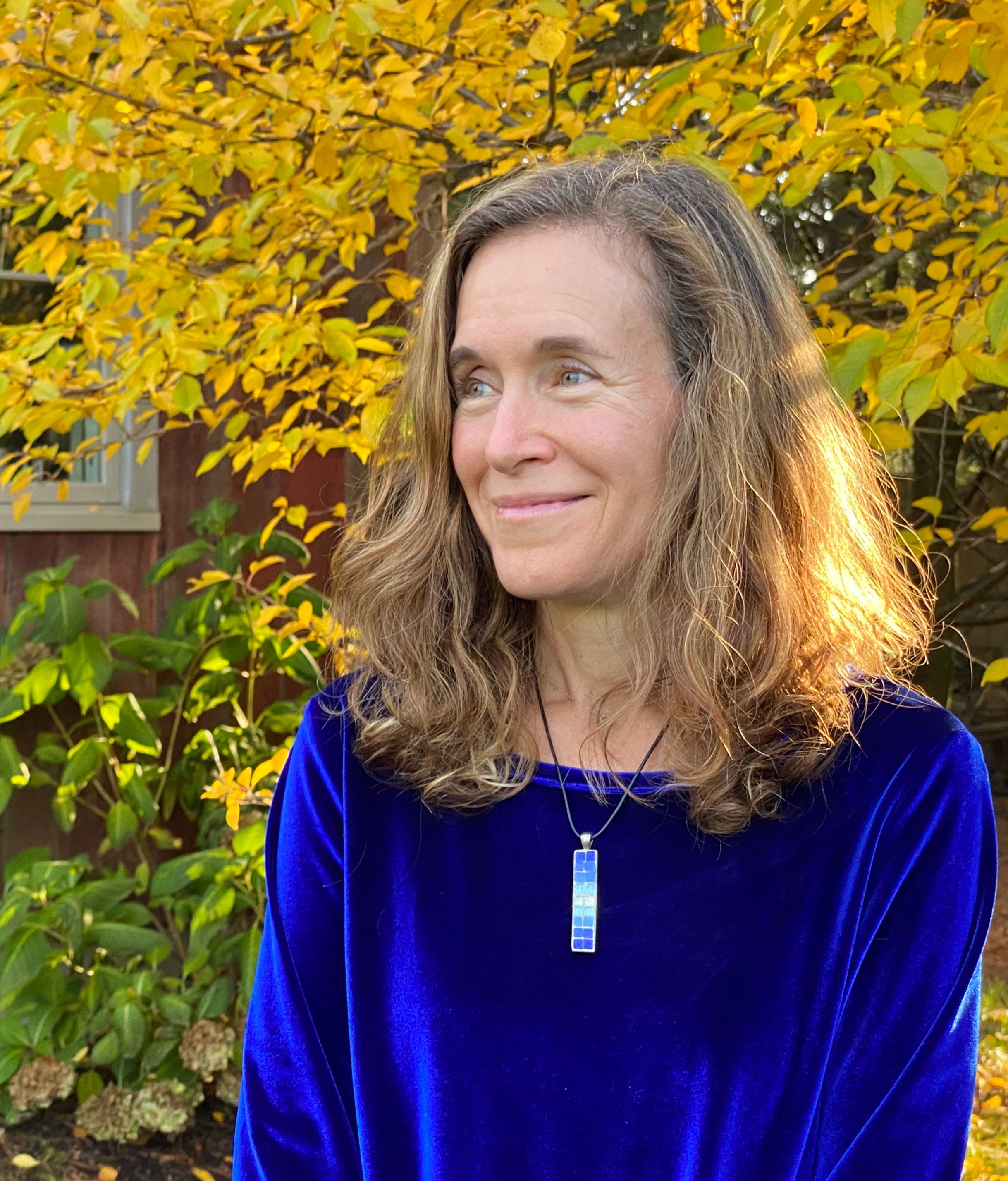 Melissa and Doug cofounder Melissa Bernstein stands in front of fall foliage in a bright blue top. melissa bernstein of melissa and doug